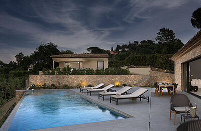 Althoff Villa Belrose in St. Tropez Côte d'Or Aussenansicht mit Pool und Liegen bei Nacht im Sommer